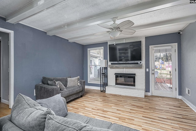 living room featuring a fireplace, beamed ceiling, and wood finished floors