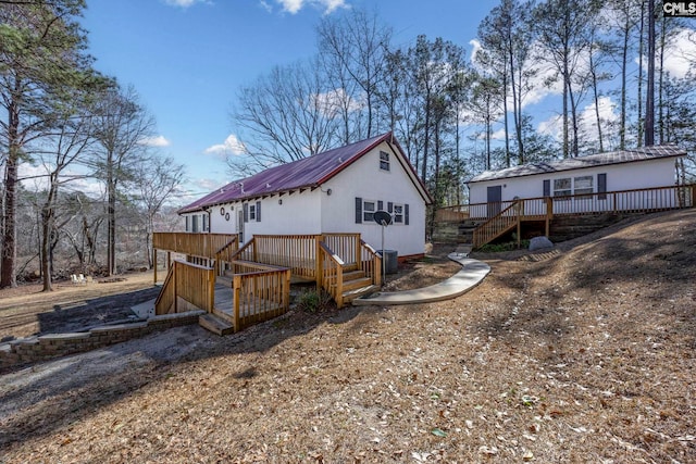 exterior space with driveway, an attached garage, stairway, and a deck