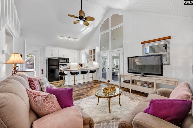 living area featuring high vaulted ceiling, french doors, ceiling fan, and wood finished floors