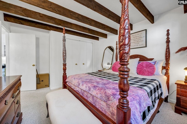 bedroom featuring a closet, beamed ceiling, and light colored carpet