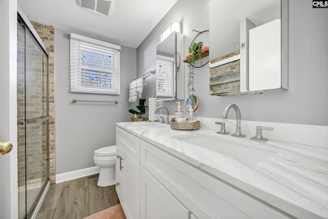 bathroom featuring a shower stall, visible vents, a sink, and wood finished floors