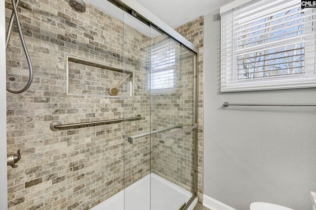 bathroom with a tile shower and toilet