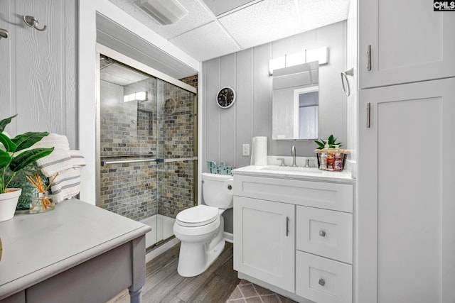 bathroom featuring a stall shower, vanity, toilet, and wood finished floors