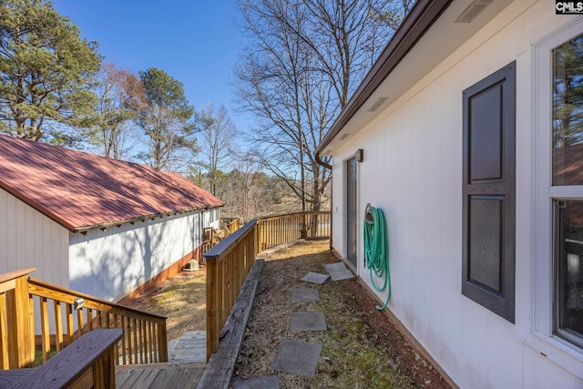 view of property exterior with a deck and metal roof