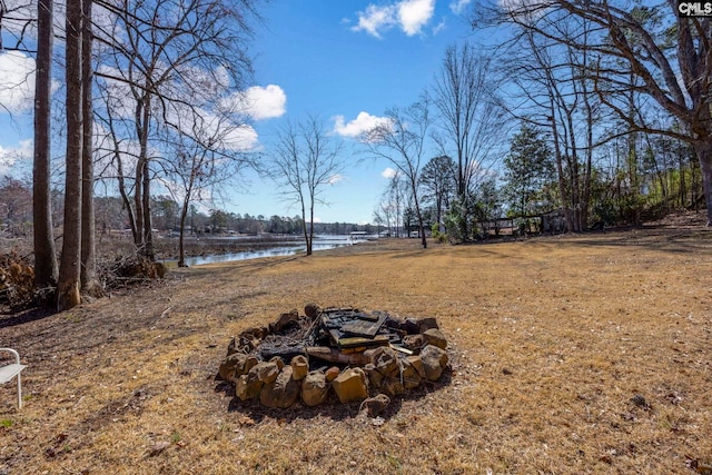 view of yard featuring an outdoor fire pit and a water view