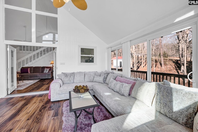 living area featuring stairs, high vaulted ceiling, dark wood finished floors, and a ceiling fan