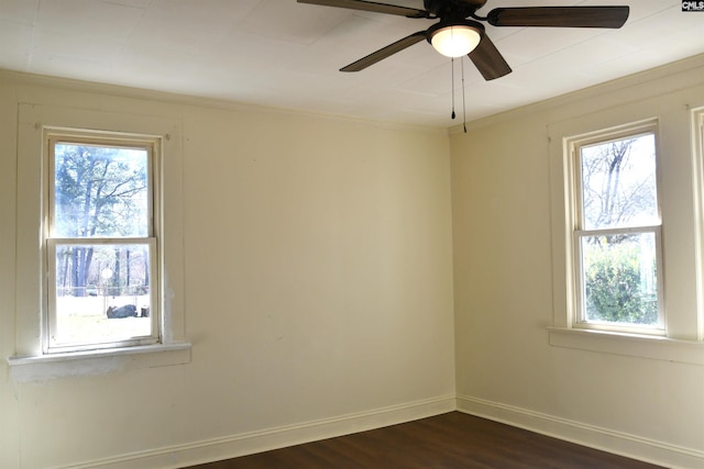 unfurnished room with crown molding, ceiling fan, dark wood finished floors, and baseboards