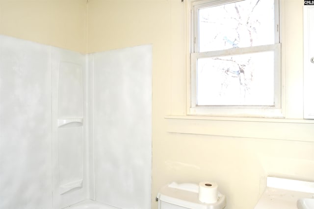 full bathroom featuring washtub / shower combination, plenty of natural light, and toilet