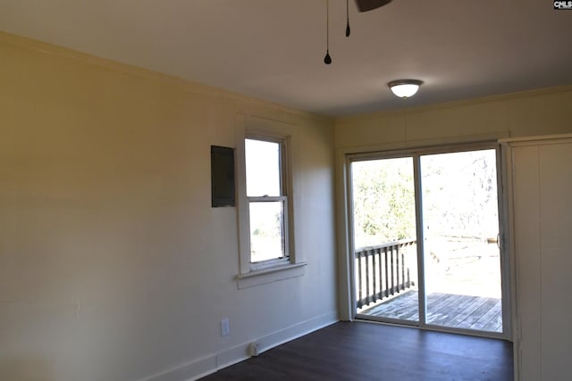 unfurnished room featuring dark wood-style floors, baseboards, electric panel, and ornamental molding