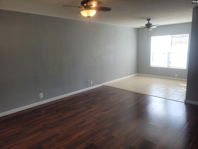 spare room featuring light wood-style flooring, baseboards, ceiling fan, and a textured ceiling