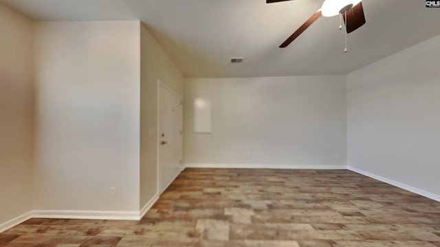 unfurnished room featuring baseboards, visible vents, and ceiling fan