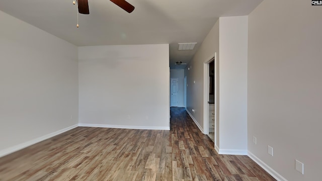 unfurnished room with a ceiling fan, visible vents, baseboards, and wood finished floors