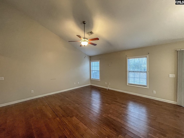 spare room with dark wood-type flooring, lofted ceiling, ceiling fan, and baseboards