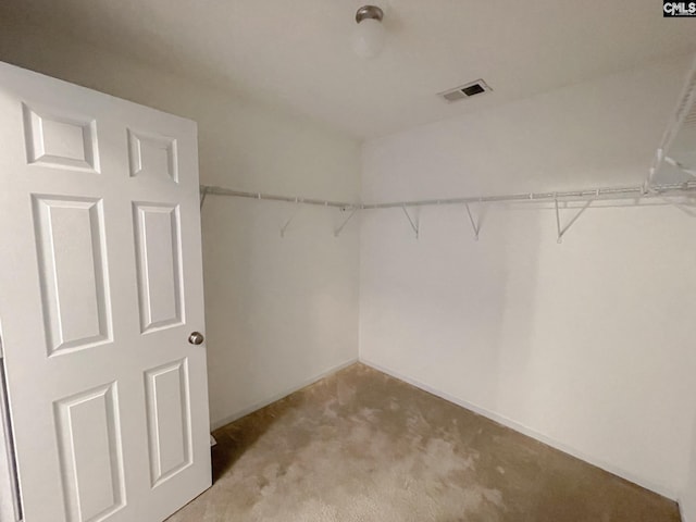 walk in closet with visible vents and light colored carpet