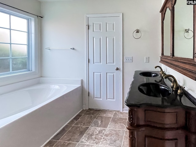 bathroom with double vanity, a sink, and a bath