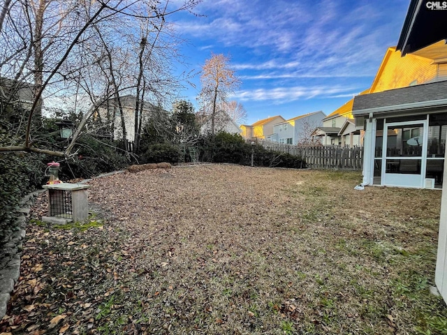 view of yard featuring a sunroom and fence