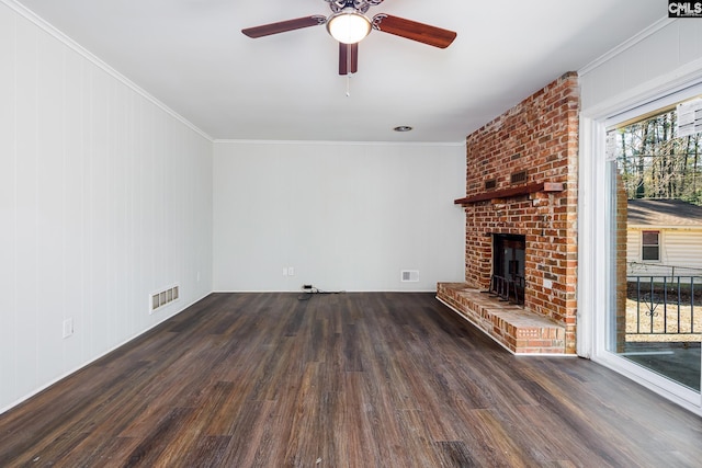 unfurnished living room featuring crown molding, a brick fireplace, visible vents, and dark wood finished floors