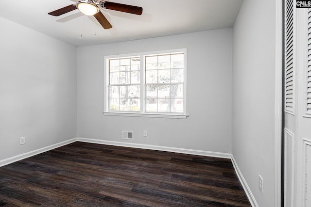 empty room featuring baseboards, visible vents, ceiling fan, and dark wood-type flooring