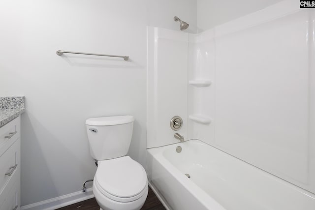 full bathroom with baseboards, toilet, vanity, wood finished floors, and shower / bathtub combination