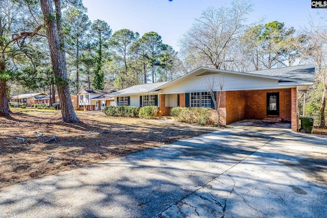 single story home featuring driveway and brick siding