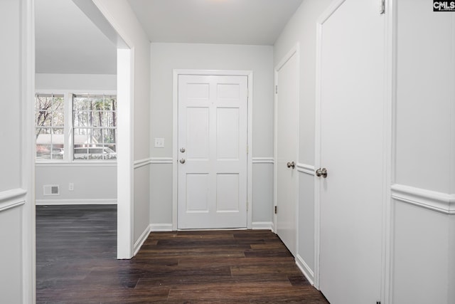 interior space featuring dark wood-style flooring, visible vents, and baseboards