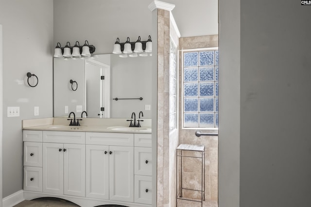 full bath featuring double vanity, a sink, and ornate columns