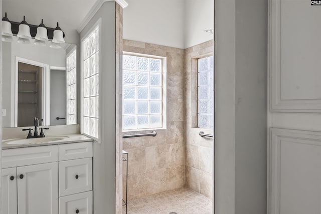 full bathroom featuring a tile shower and vanity