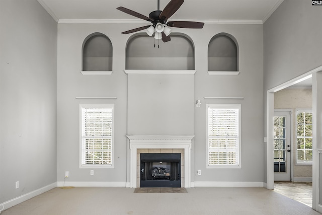 unfurnished living room with ornamental molding, a wealth of natural light, and a tile fireplace