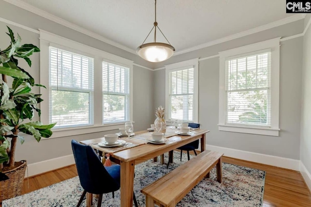 dining area with crown molding, baseboards, and wood finished floors