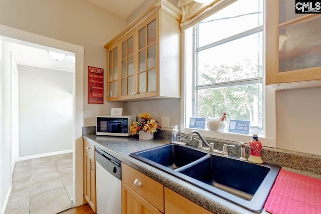 kitchen with a sink, white microwave, glass insert cabinets, and dishwasher