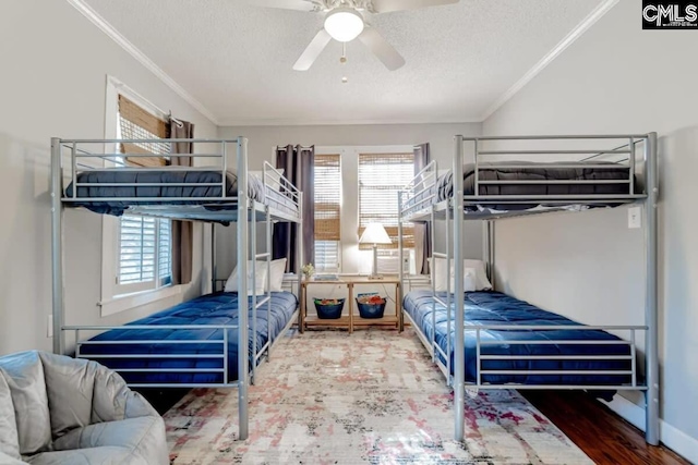 bedroom featuring a textured ceiling, a ceiling fan, crown molding, and wood finished floors