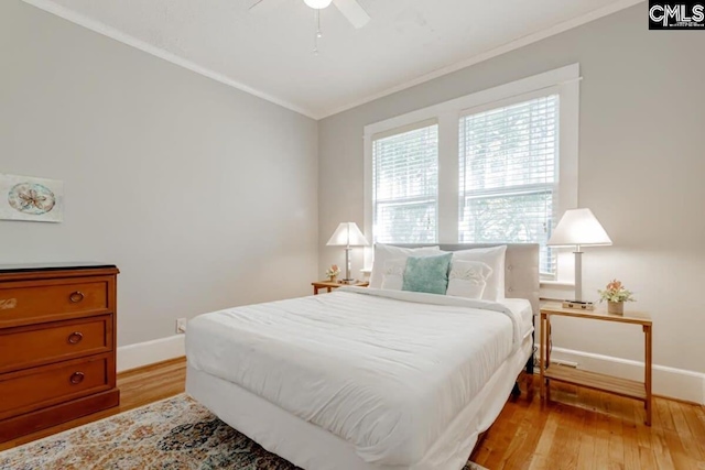 bedroom featuring ornamental molding, ceiling fan, light wood finished floors, and baseboards