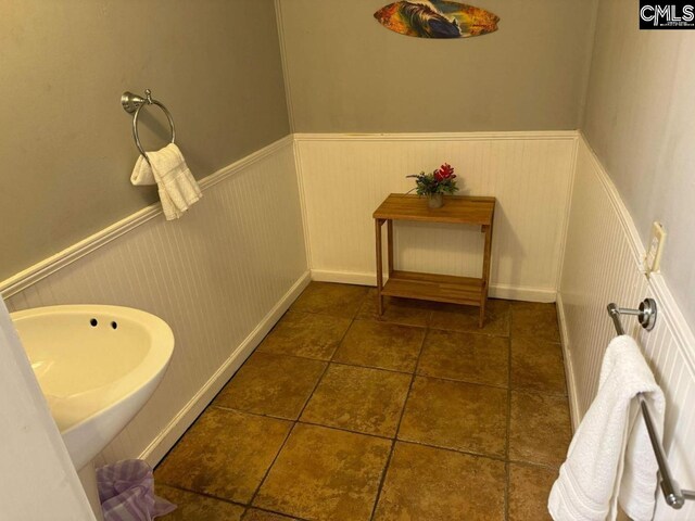 bathroom featuring wainscoting, a sink, and tile patterned floors