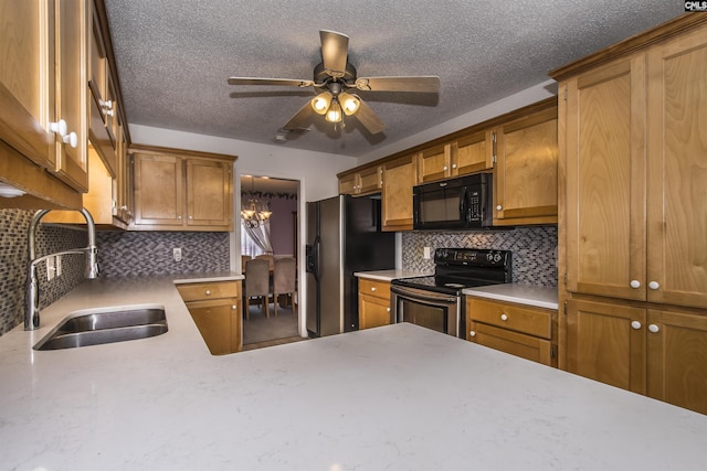 kitchen with a sink, light countertops, backsplash, brown cabinets, and black appliances