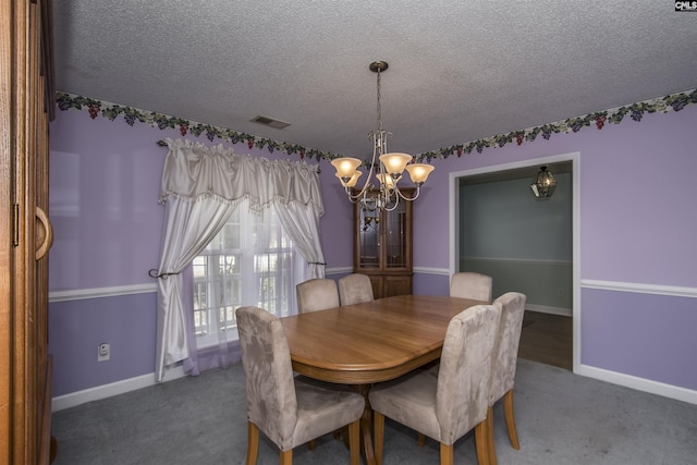 carpeted dining area with a textured ceiling, baseboards, visible vents, and a notable chandelier