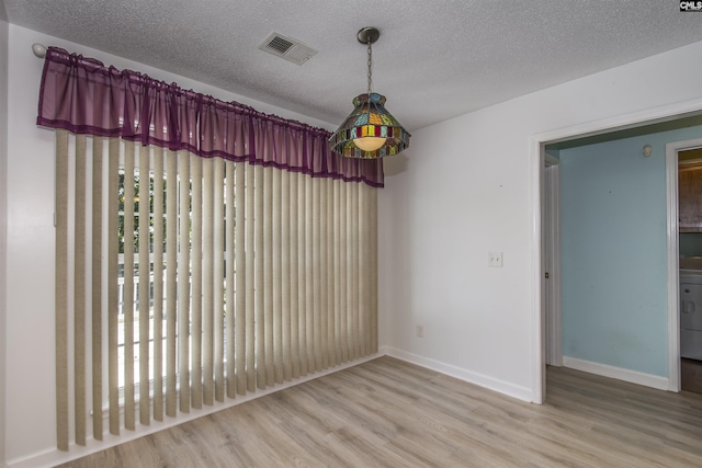 interior space featuring visible vents, a textured ceiling, and wood finished floors