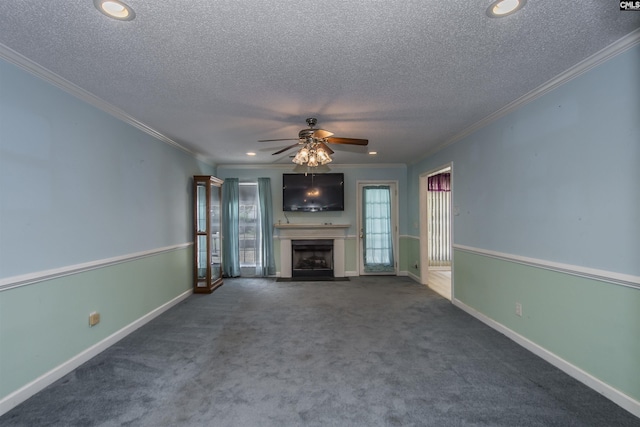 unfurnished living room with baseboards, dark colored carpet, crown molding, a textured ceiling, and a fireplace