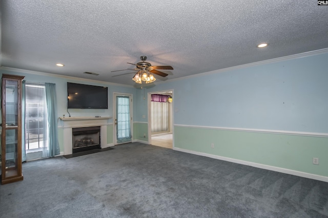 unfurnished living room featuring a fireplace with flush hearth, visible vents, baseboards, carpet, and crown molding