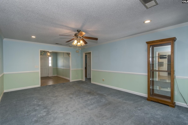 empty room featuring visible vents, dark carpet, baseboards, and ornamental molding