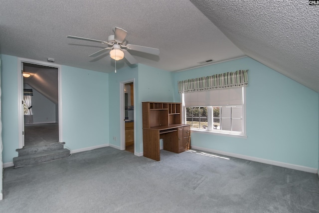 unfurnished living room with carpet, vaulted ceiling, a textured ceiling, and baseboards