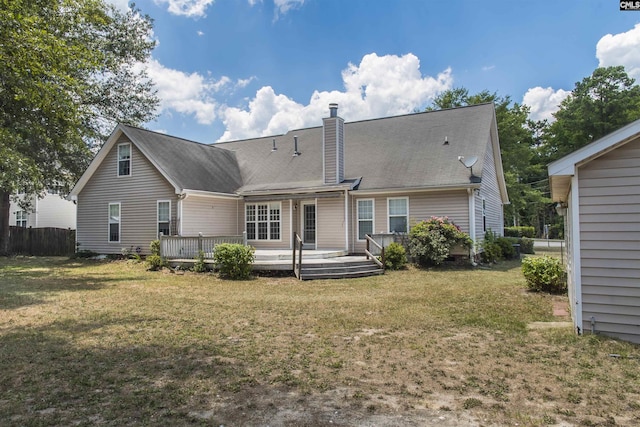 back of property with a yard, a chimney, fence, and a wooden deck