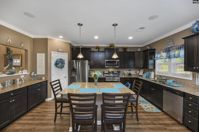 kitchen with a breakfast bar, pendant lighting, visible vents, appliances with stainless steel finishes, and dark wood-type flooring