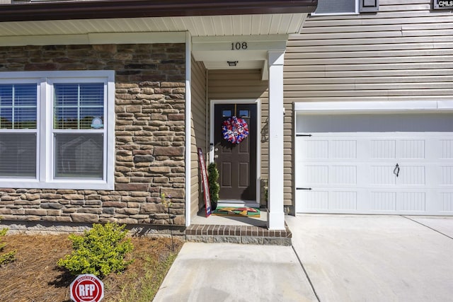 entrance to property with stone siding and concrete driveway