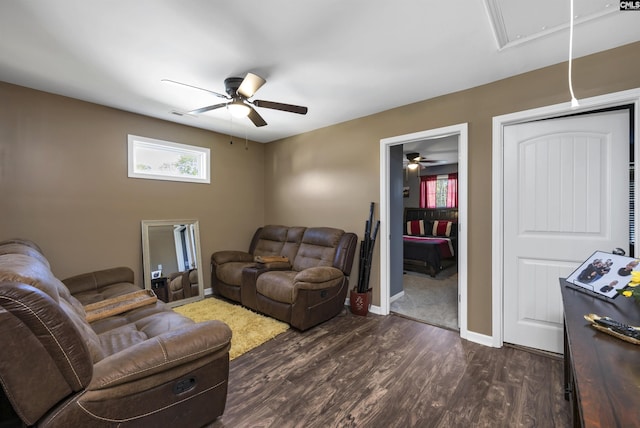 living area featuring attic access, visible vents, baseboards, a ceiling fan, and dark wood-style floors