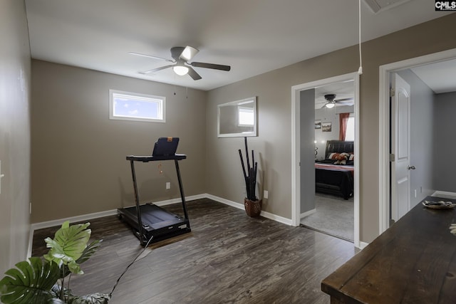 exercise area featuring attic access, baseboards, dark wood finished floors, and a ceiling fan