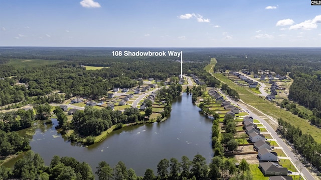 aerial view featuring a forest view, a water view, and a residential view