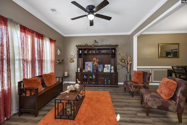 living room with crown molding, visible vents, dark wood-type flooring, ceiling fan, and baseboards