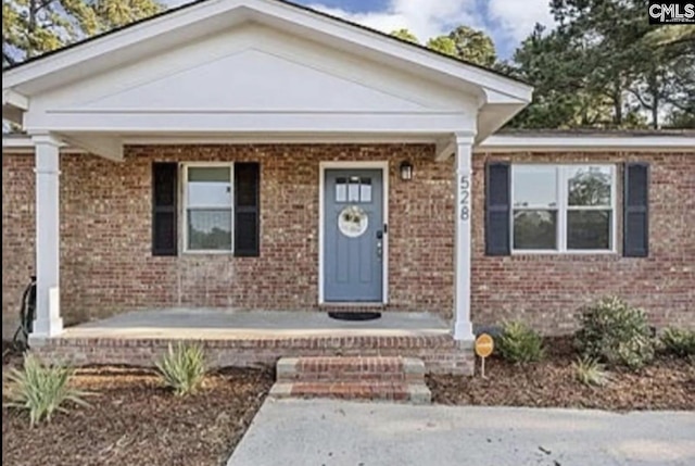 view of front of property featuring covered porch and brick siding