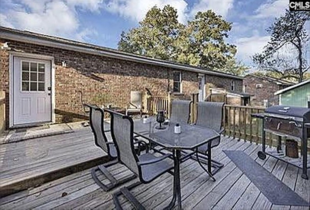 wooden terrace featuring grilling area and outdoor dining space