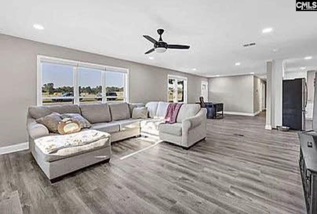 living room with dark wood-type flooring, recessed lighting, and baseboards